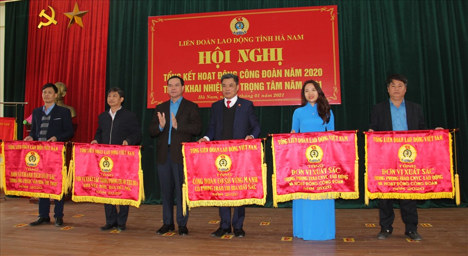 Chủ tịch Tổng LĐLĐ Việt Nam Nguyễn Đình Khang tặng Cờ của Tổng LĐLĐ Việt Nam cho các tập thể có thành tích xuất sắc trong phong trào thi đua năm 2020. Ảnh: Phúc Lộc