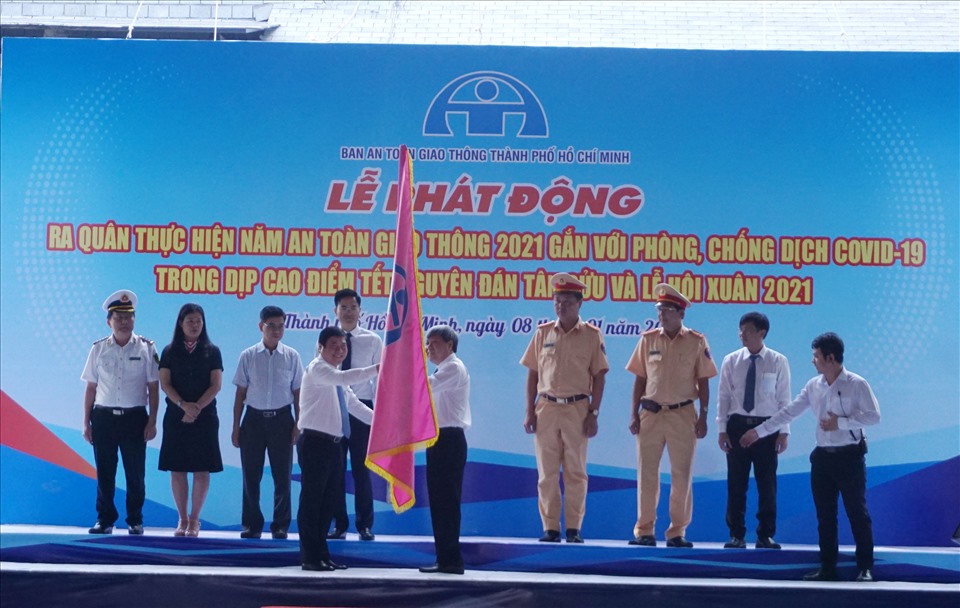 Chủ tịch UBND TPHCM Nguyễn Thành Phong trao cờ lệnh ra quân thực hiện Năm ATGT 2021 cho Ban ATGT TPHCM.  Ảnh: Minh Quân
