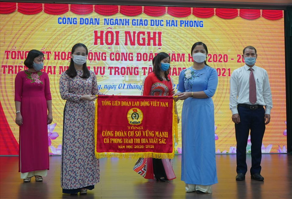 Đại diện lãnh đạo Liên đoàn Lao động TP.Hải Phòng trao cờ thi đùa của Tổng LĐLĐ Việt Nam tặng tập thể xuất sắc. Ảnh Mai Dung
