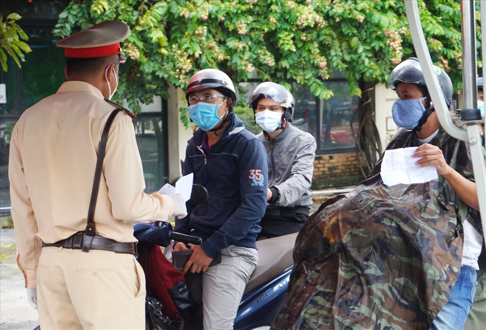 Lực lượng chức năng tỉnh Bình Dương kiểm tra giấy tờ người đi xe máy từ TPHCM qua.  Ảnh: Minh Quân