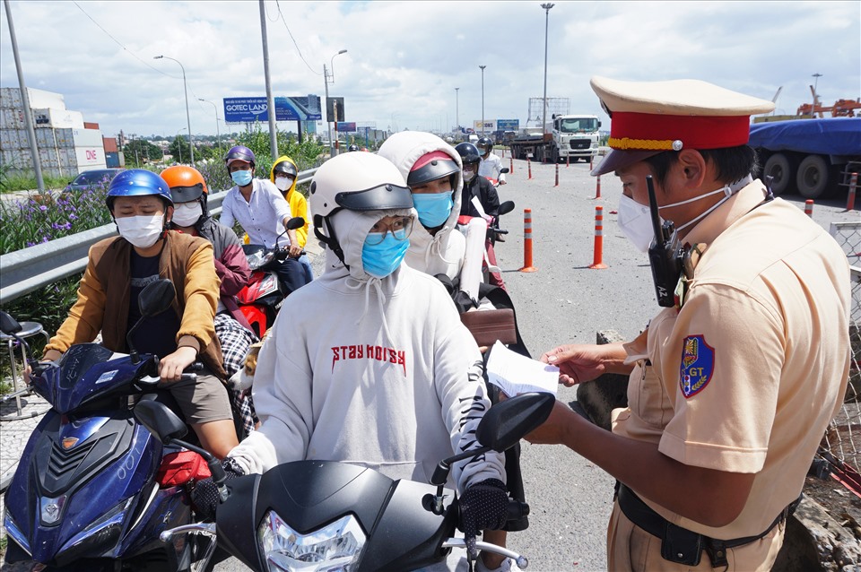 Lực lượng chức năng kiểm tra giấy tờ người đi xe máy từ Đồng Nai qua.