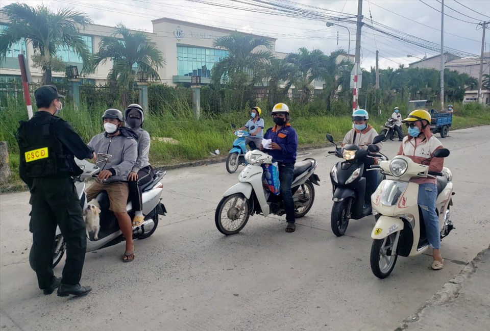 Lực lượng chức năng tỉnh Đồng Nai kiểm tra giấy tờ người đi xe máy từ TPHCM và Bình Dương qua.  Ảnh: Hà Anh Chiến