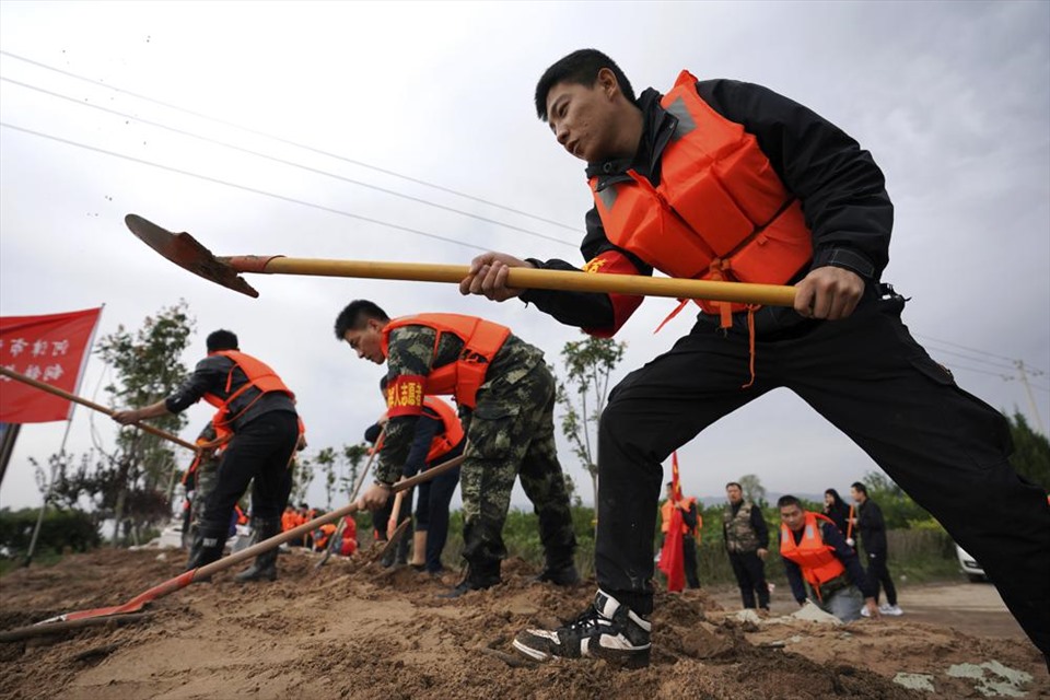 Lực lượng cứu hộ đang gia cố một con đê tạm thời chống lũ lụt tại làng Lianbo ở thành phố Hejin, thuộc tỉnh Sơn Tây, miền bắc Trung Quốc, Chủ nhật, ngày 10 tháng 10 năm 2021.