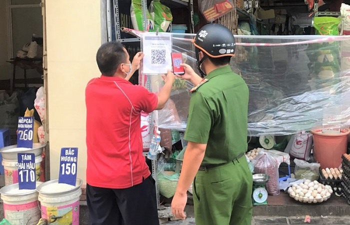Lực lượng chức năng phường Vĩnh Tuy (quận Hai Bà Trưng) nhắc nhở các hộ kinh doanh thực hiện việc quét mã QR.