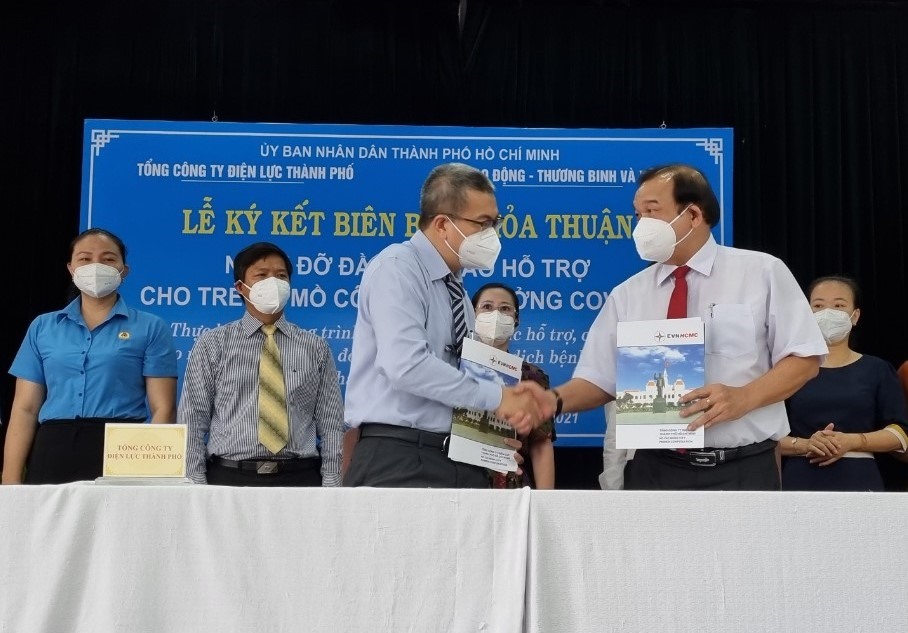 Ông Lê Minh Tấn, Giám đốc Sở LĐTBXH TPHCM và ông Nguyễn Văn Thanh, Tổng giám đốc EVNHCMC ký kết thỏa thuận nhận đỡ đầu cho trẻ em có cah, mẹ chết vì COVID-19. Ảnh: Nam Dương