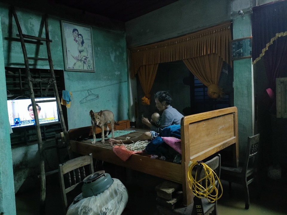 Một người dân tại thôn Quy Hậu (xã Liên Thủy, huyện Lệ Thủy) đang ngồi trên chiếc giường được kê cao để tránh lũ. Ảnh: H.L