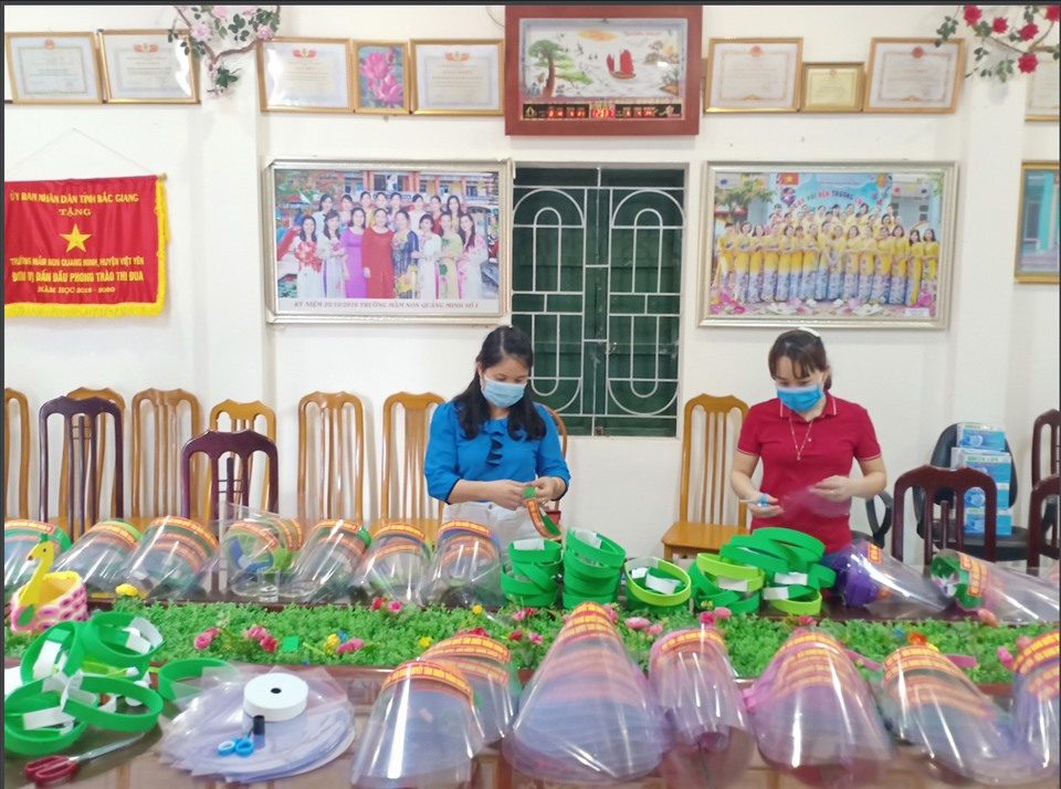Cô giáo Cao Thị Vân (bên trái) cùng đồng nghiệp làm mũ chắn giọt bắn tặng lực lượng tuyến đầu chống dịch. Ảnh: NVCC.