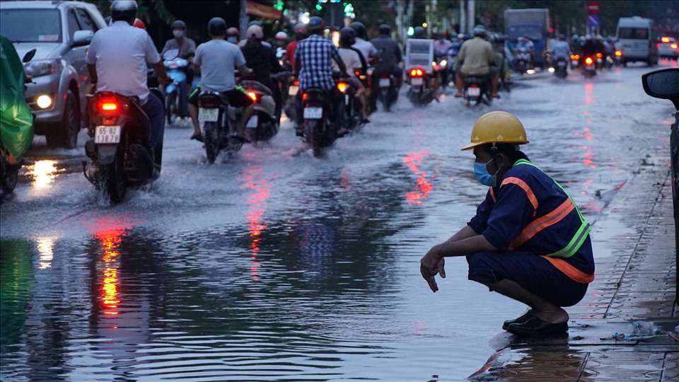 Công nhân Công ty Thoát nước Cần Thơ khơi cống ở đường phố sau trận mưa lớn.