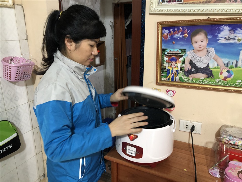 Chị Nguyễn Thị Hiền vừa nấu cơm, vừa trông con học online. Ảnh: Bảo Hân