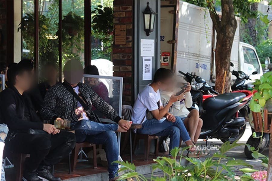 Khách hàng tụm năm, tụm ba trò chuyện ở quán cà phê trên phố Trần Huy Liệu dù không đảm bảo khoảng cách an toàn theo đúng quy định phòng dịch COVID-19.