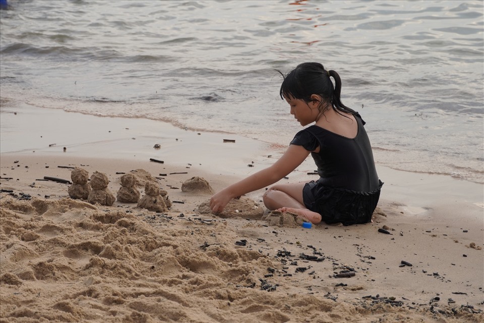 Chán tắm biển vẫn có thể chơi trên bãi cát. Một em gái đã tỉ mẫn để chỉnh sửa tác phẩm của mình cho hoàn thiện theo ý thích. Ảnh: T.A