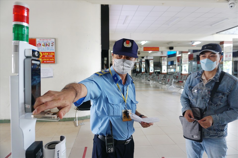 Bảo vệ bến xe Miền Đông kiểm tra giấy xét nghiệm và chứng nhận tiêm vaccine của hành khách.  Ảnh: Minh Quân