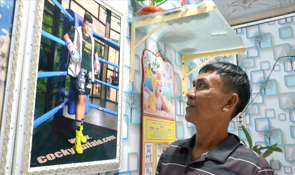 Anh Chau Kim Thương - dân tộc Khmer ngắm hình con gái trong tại ngôi nhà cuối hẻm 11, khóm 6, thị trấn Tri Tôn, nơi nhà vô địch WBO sinh ra và lớn lên. Ảnh: LT