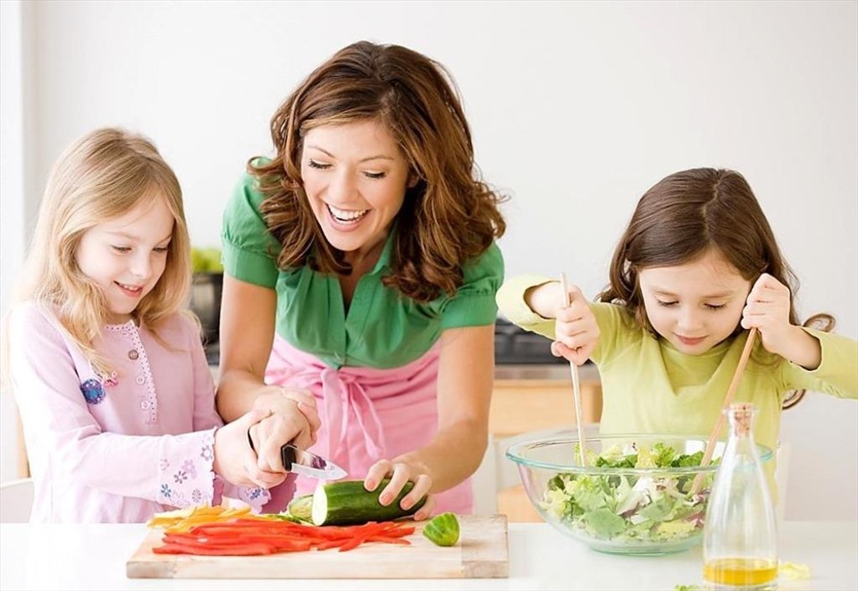 Hãy cùng trẻ chế biến các món ăn cũng là cách để các bé tự nguyện ăn rau xanh. Ảnh: Xinhua