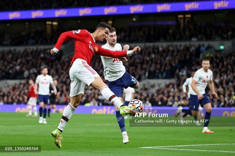 Christiano Ronaldo tung cú vô lê góc hẹp mở tỉ số cho Manchester United trước Tottenham Hotspur. Ảnh: AFP