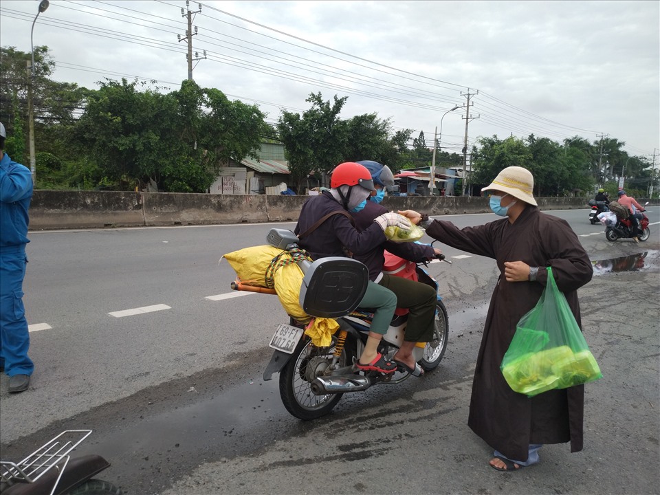 Chút thức ăn, nước uống cho người lao động nghèo trên đường về Cà Mau xa thăm thẳm. Ảnh: K.Q