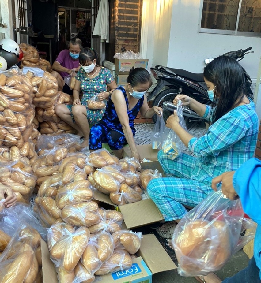 Cung cấp bánh mì cho người dân chờ sàng lọc để đến khu cách ly tại tỉnh Cà Mau. Ảnh: Sa Thương