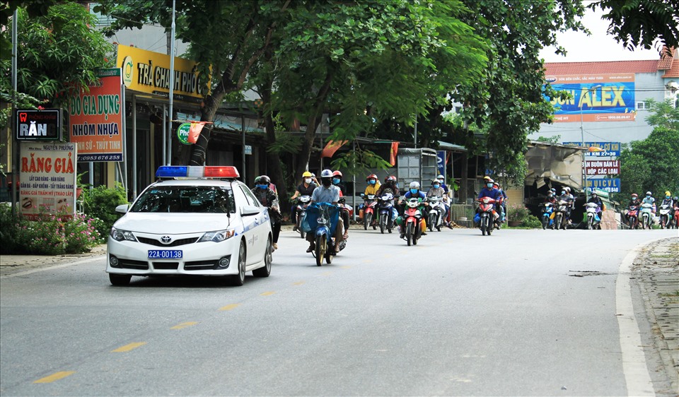 Để đảm bảo an toàn giao thông cho đoàn người lao động Hà Giang trở về từ các tỉnh phía nam, lực lượng CSGT tỉnh Tuyên Quang đã bố trí xe dẫn đoàn hộ tống trên Quốc lộ 2. Ảnh: Phong Quang