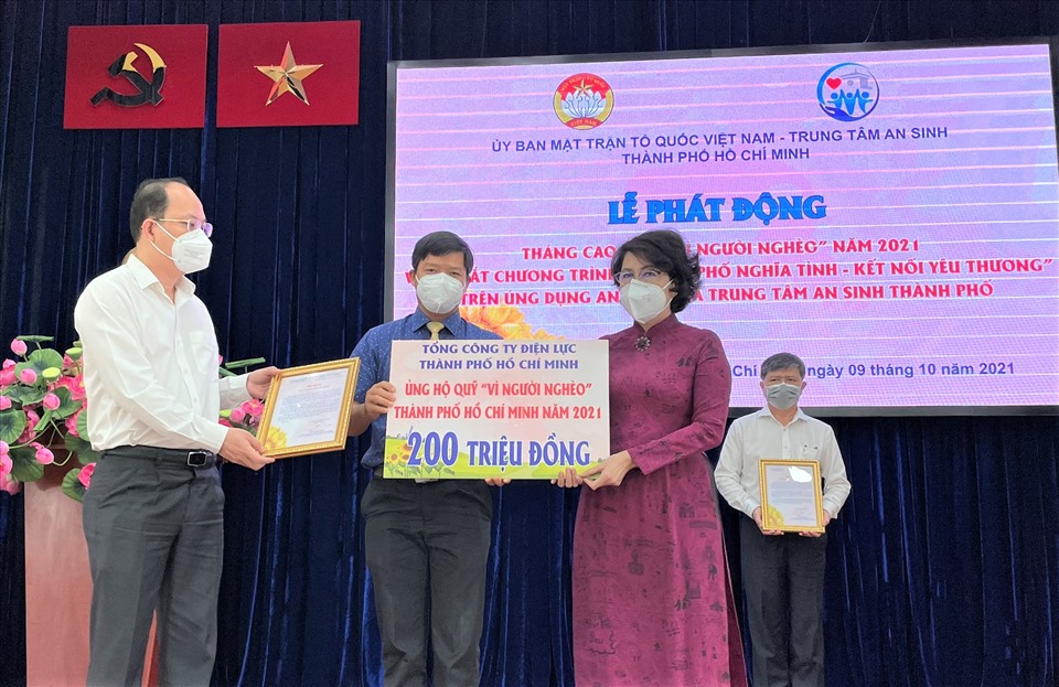 Ông Lê Văn Minh (giữa), Chủ tịch Công đoàn Tổng Công ty Điện lực TPHCM trao biển tượng trưng hỗ trợ Quỹ “Vì người nghèo” TPHCM. Ảnh: Nam Dương