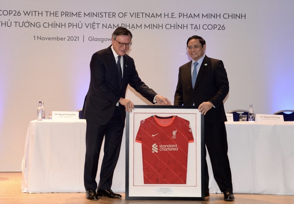 Chủ tịch Ngân hàng Standard Chartered Jose Vinals tặng Thủ tướng Phạm Minh Chính áo thi đấu của đội bóng Liverpool. Ảnh: VGP