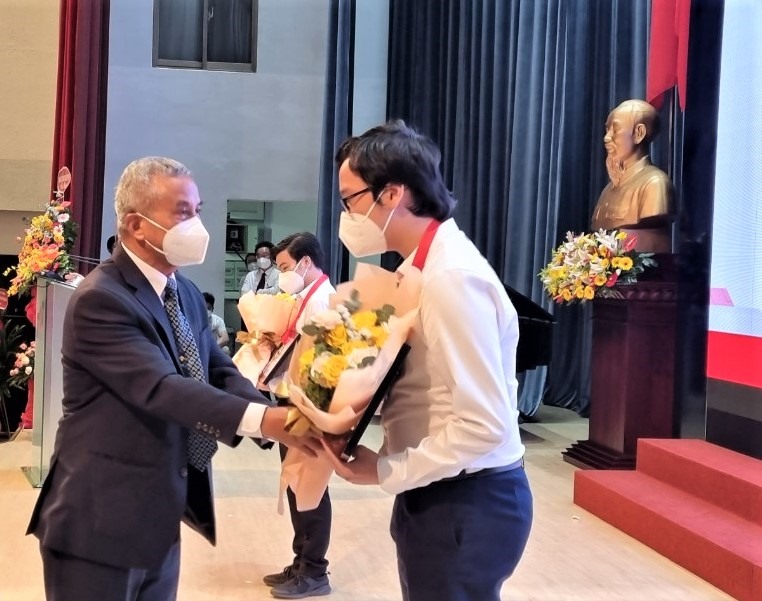 Nguyên Chủ tịch Tổng LĐLĐ Việt Nam Đặng Ngọc Tùng tặng hoa cho sinh viên có thành tích tốt trong học tâp. Ảnh: Nam Dương