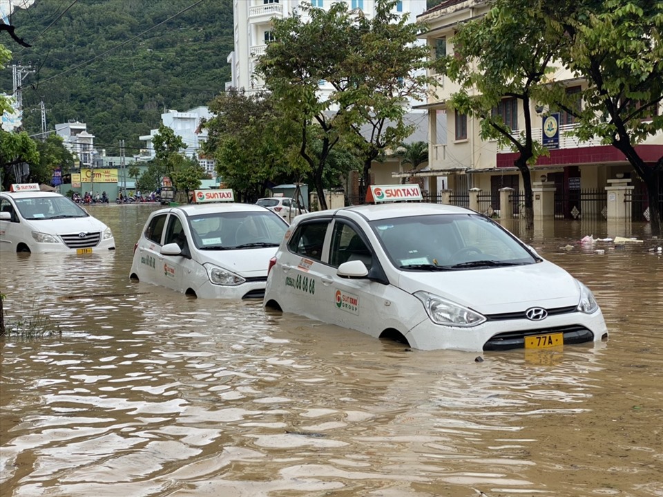Nước ngập dâng cao kéo dài hơn 1km, hàng chục xe taxi đậu ven đường không kịp di chuyển bị nước nhấn chìm. Nhiều chiếc xe bị đẩy trôi dạt, va đập gây hư hỏng. Ảnh: D.P