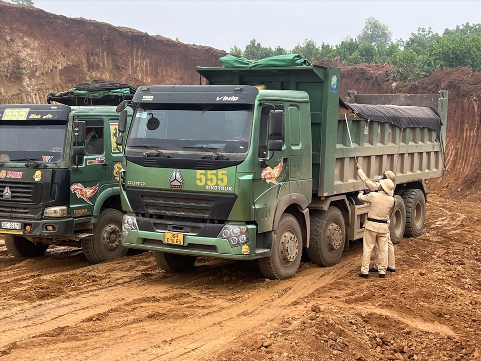 Lực lượng CSGT, Công an huyện Hà Trung (Thanh Hóa) vào cuộc kiểm tra đoàn xe tải chở đất ngay tại khu vực mỏ đất. Ảnh: CATH