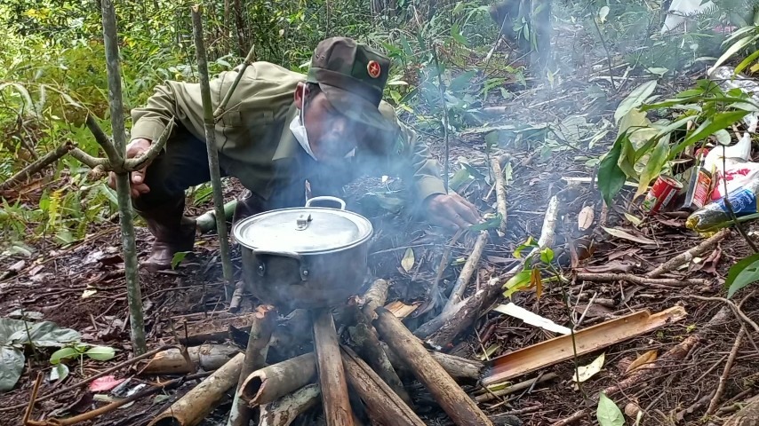 Lực lượng bảo vệ rừng nhọc nhằn nhóm lửa nấu ăn giữa rừng. Ảnh: Phan Tuấn