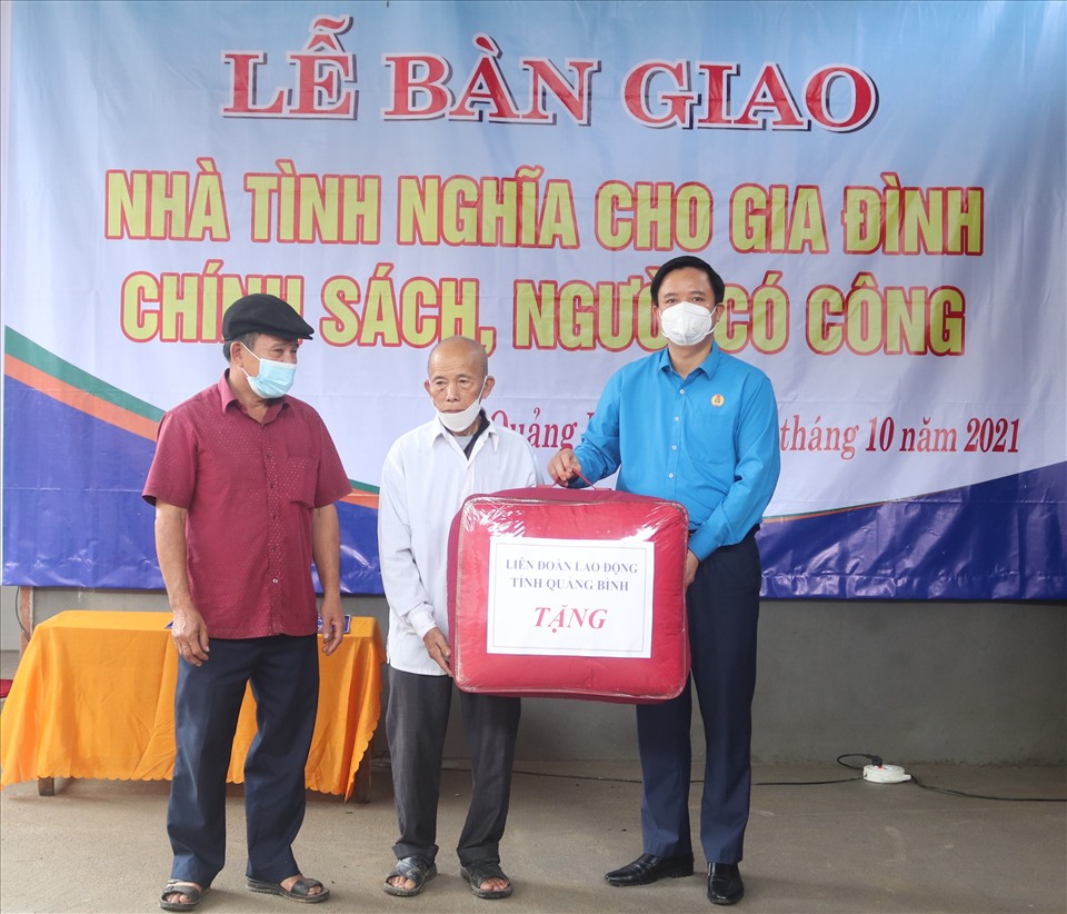 Ông Phạm Tiến Nam - Chủ tịch LĐLĐ tỉnh Quảng Bình trao quà cho ông Lương tại buổi bàn giao nhà. Ảnh: LPL