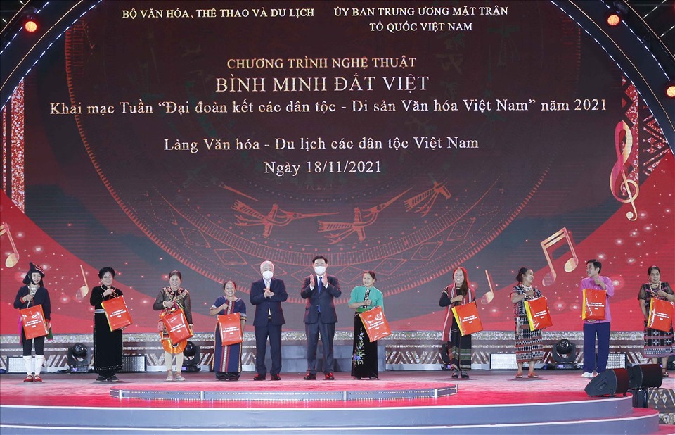 Chủ tịch Quốc hội Vương Đình Huệ và Chủ tịch Ủy ban Trung ương MTTQ Việt Nam Đỗ Văn Chiến trao quà cho các đại biểu dân tộc tại Làng Văn hóa.