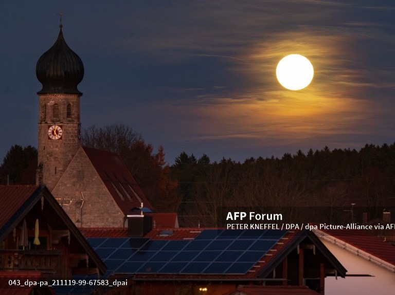 Mặt trăng tròn trên nhà thờ của làng Warngau thuộc vùng Thượng Bavaria, Đức. Ảnh: AFP