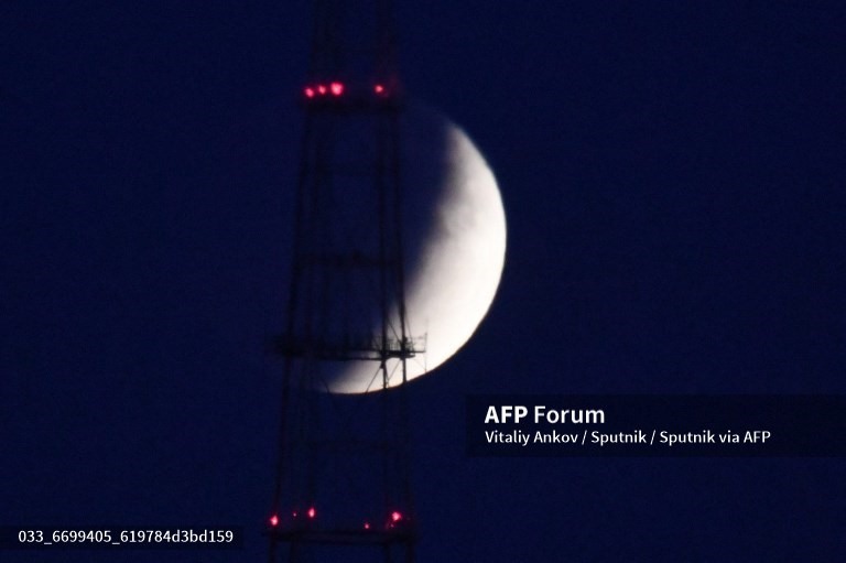 Bóng đen bao phủ Mặt trăng khi nó trải qua nguyệt thực một phần. Ảnh được chụp ở Vladivostok, Nga. Ảnh: AFP