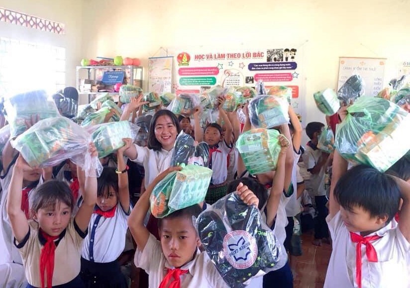 Các em học sinh nghèo phấn khởi khi được nhận quà từ cô Hương.