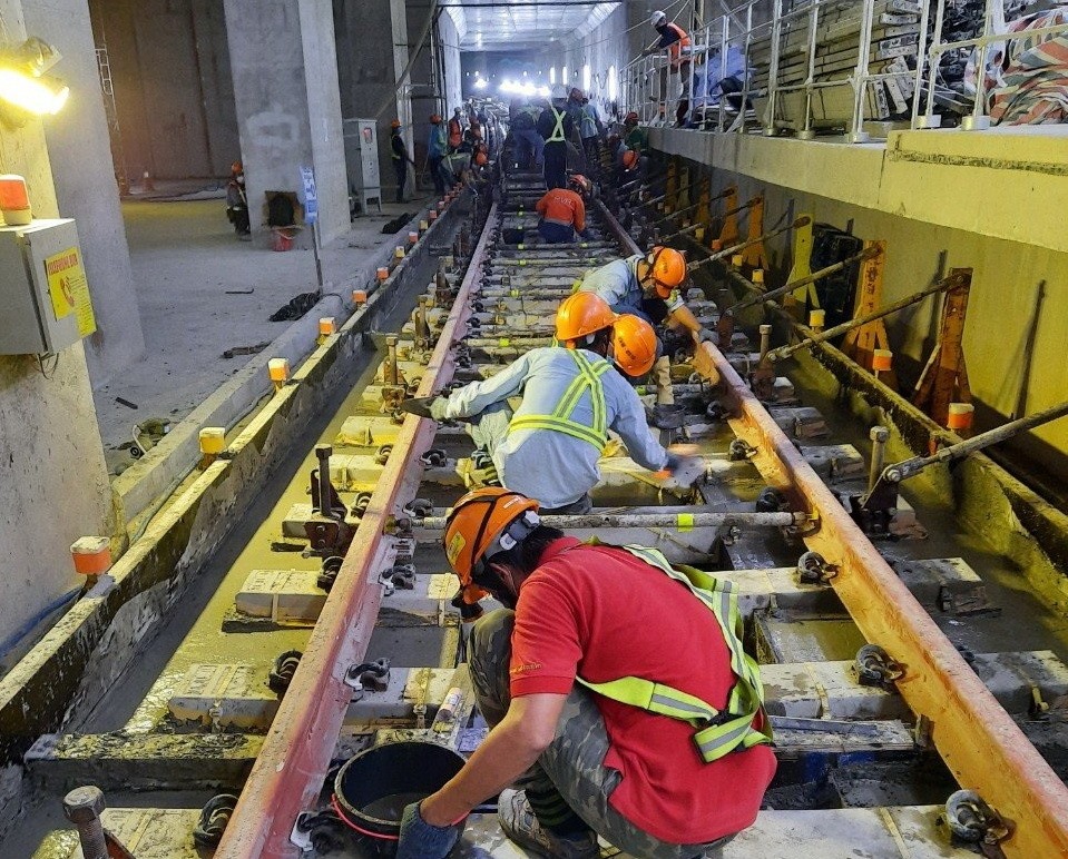 Công nhân thi công lắp đặt đoạn ray cuối cùng của metro số 1.  Ảnh: MAUR