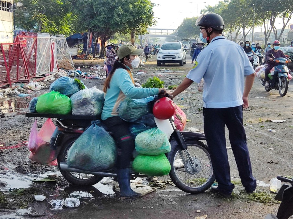 Lức lượng chức năng phường Tam Bình nhắc nhở người buôn bán tự phát trước chợ đầu mối nông sản Thủ Đức.  Ảnh: Minh Quân