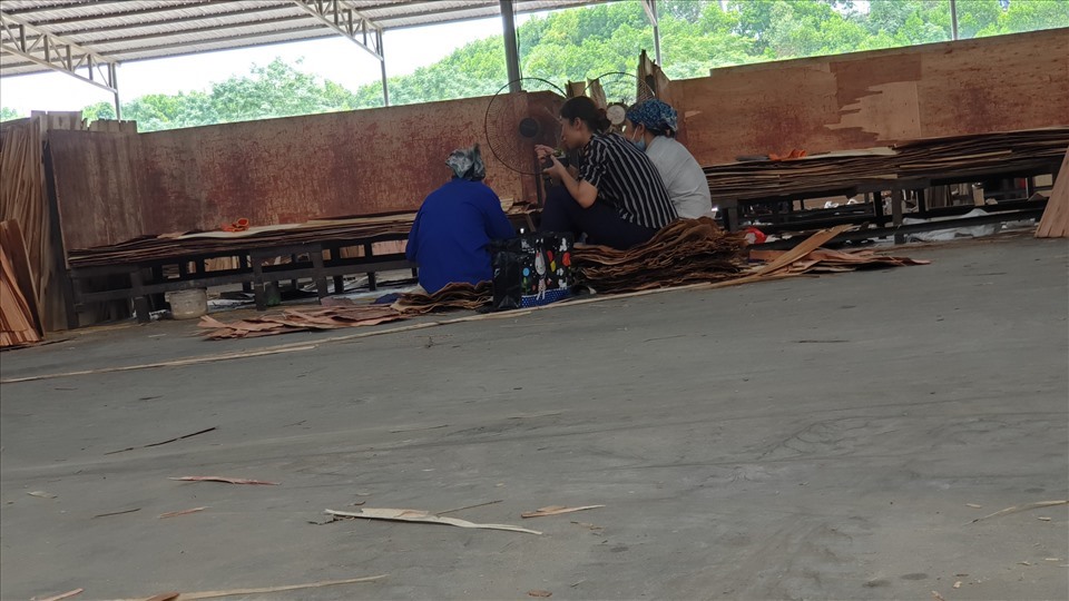 Ngồi trên những tấm ván gỗ, các công nhân ăn vội vã bữa trưa tự mang từ nhà đi. Ảnh: AT.