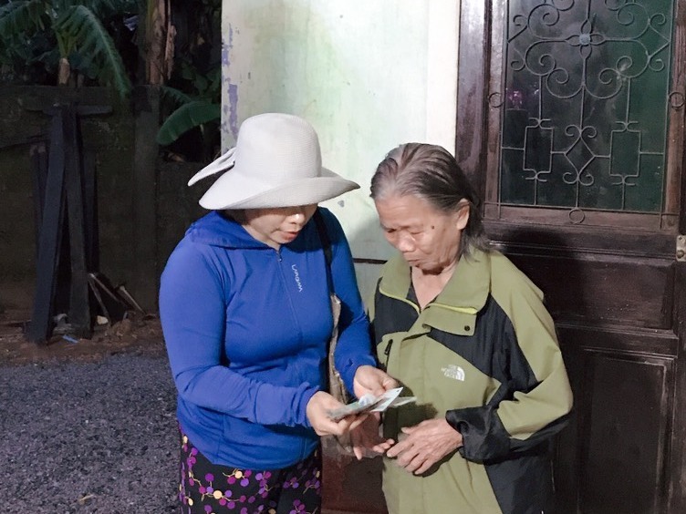 Bà Huyên thay mặt ca sĩ Thủy Tiên gửi tiền hỗ trợ cho 1 hộ có hoàn cảnh khó khăn ở thôn Võ Xá. Ảnh: NVCC.