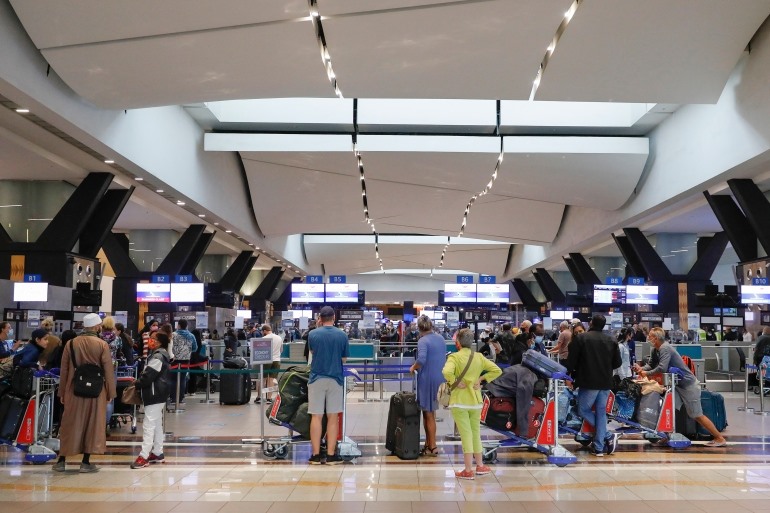 Du khách xếp hàng tại quầy làm thủ tục ở sân bay quốc tế OR Tambo, Johannesburg, Nam Phi, ngày 27.11.2021, sau khi một số quốc gia áp dụng các hạn chế du lịch mới do phát hiện ra biến thể Omicron. Ảnh: AFP