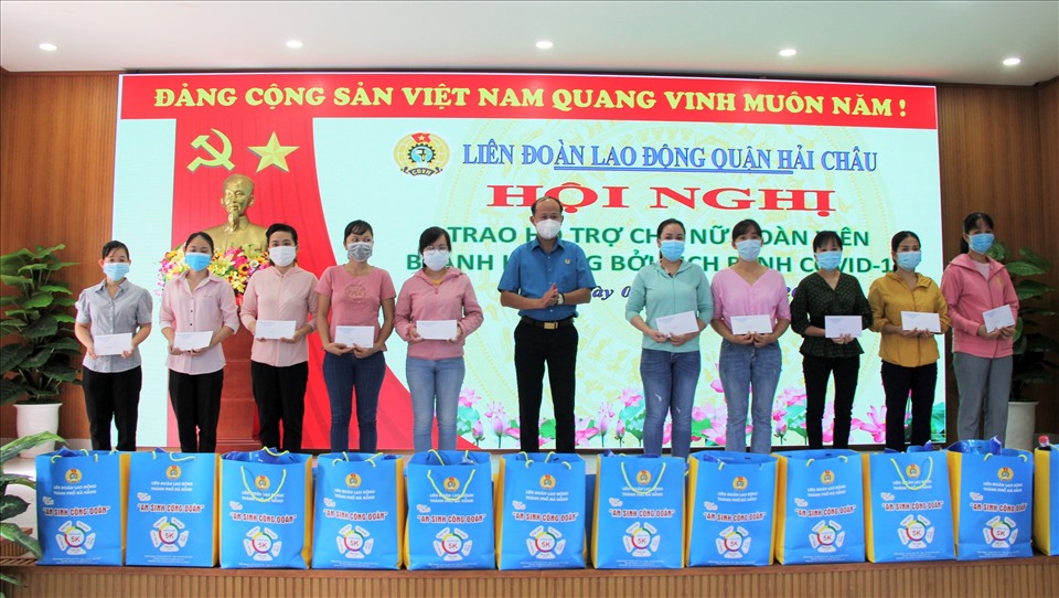 Phó Chủ tịch LĐLĐ TP Đà Nẵng Lê Văn Đại (đứng giữa) trao quà hỗ trợ cho đoàn viên, người lao động bị ảnh hưởng dịch COVID-19. Ảnh: Đức Quang.