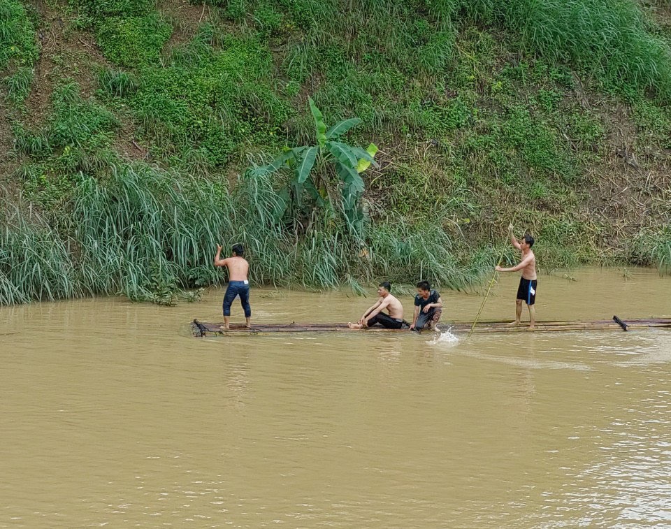 Người dân xã Cư San (huyện M'Đrắk) chèo thuyền tìm kiếm thi thể một người phụ nữ bị nước cuốn trôi. Ảnh: Bảo Trung