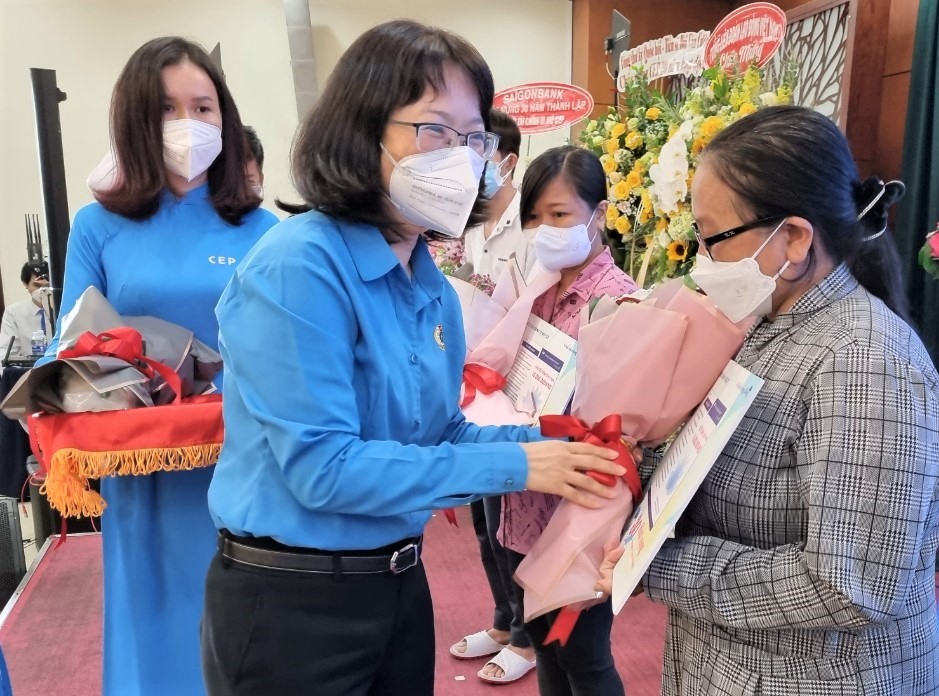 Bà Trần thị Diệu Thúy, Chủ tịch LĐLĐ TPHCM trao sổ tiết kiệm và tặng hoa các khách hàng tiêu biểu của CEP. Ảnh: Nam Dương