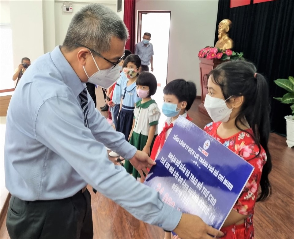 Ông Nguyễn Văn Thanh - Tổng giám đốc EVNHCMC - trao hỗ trợ cho các em thiếu nhi có cha, mẹ chết do dịch COVID-19. Ảnh: Nam Dương