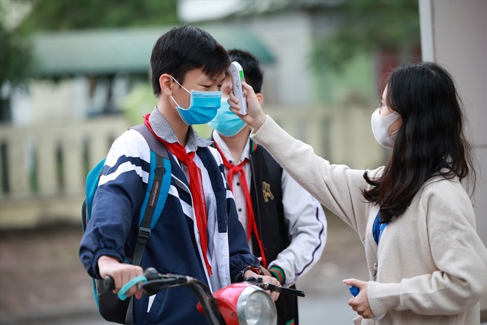 Học sinh đo thân nhiệt trước khi vào trường học. Ảnh: Hải Nguyễn.