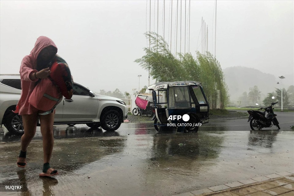 Người dân đi tránh bão. Ảnh: AFP