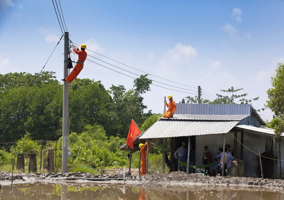 Nhân viên EVNSPC gắn điện miễn phí cho hộ nghèo tại tỉnh Cà Mau. Ảnh: EVNSPC cung cấp