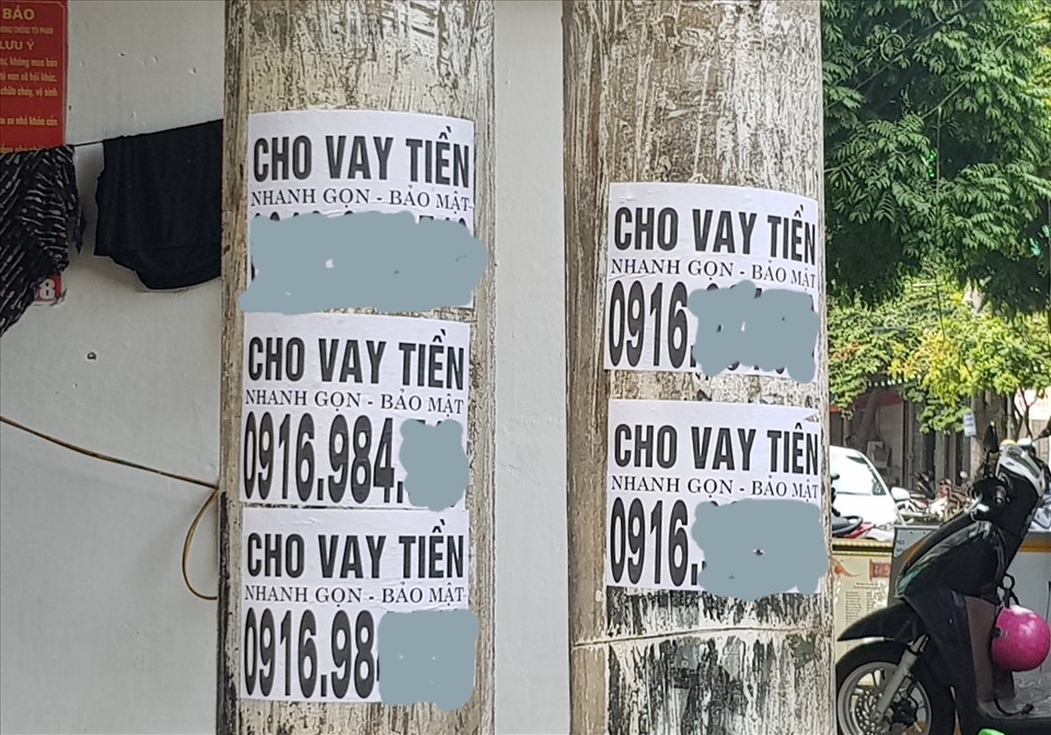 Tờ rơi quảng cáo cho vay tiền được dán chi chít tại các cột điện dọc 2 bên đường Hải Thượng Lãn Ông (thành phố Ninh Bình). Ảnh: NT