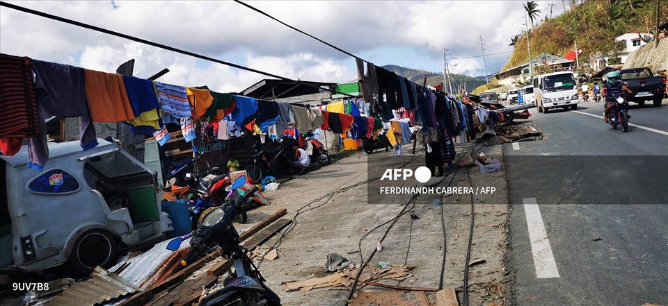 Người dân phơi quần áo trên dây từ cột điện bị sập ở thành phố Surigao. Ảnh: AFP