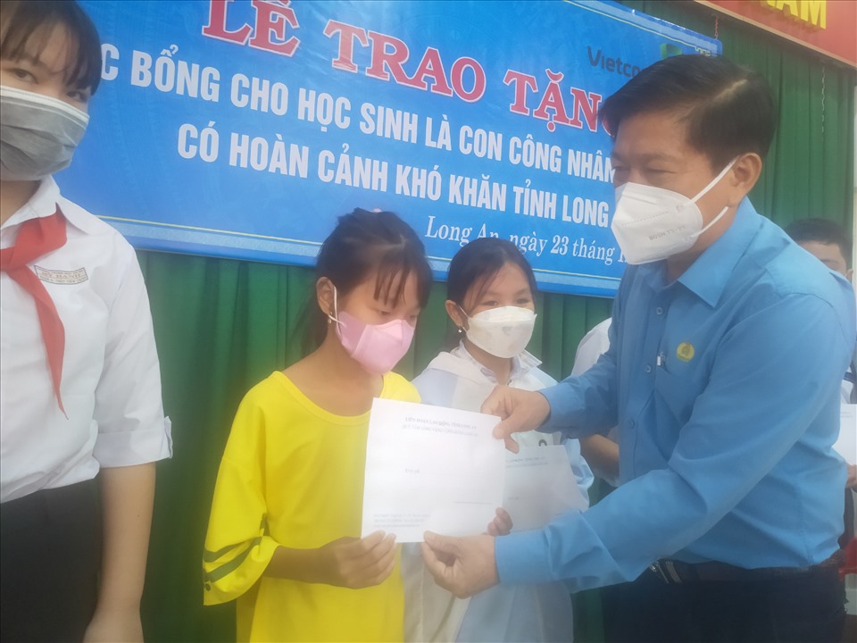 Chủ tịch LĐLĐ tỉnh Long An - ông Nguyễn Văn Quí - trao học bổng cho các học sinh. Ảnh: N.T