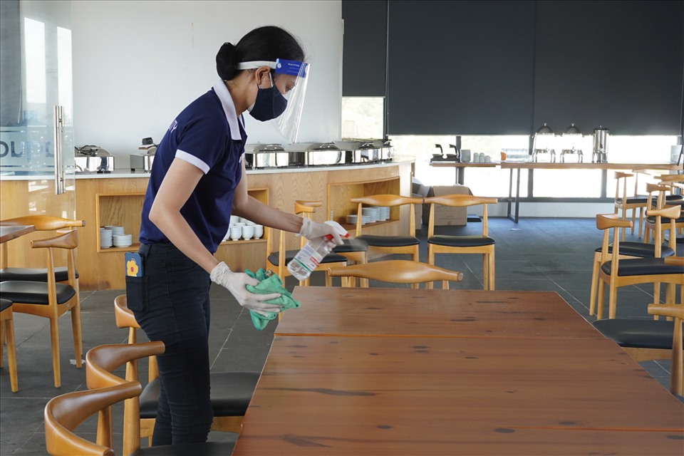 Nhân viên phun khử khuẩn trong lúc dọn dẹp trước khi khách lưu trú sử dụng vậy dụng trong cơ sở. Ảnh: T.A