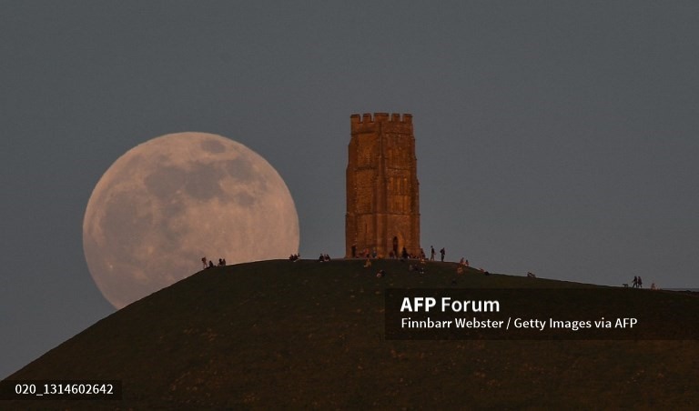 Siêu trăng mọc sau ngọn đồi Glastonbury Tor, Anh. Ảnh: AFP